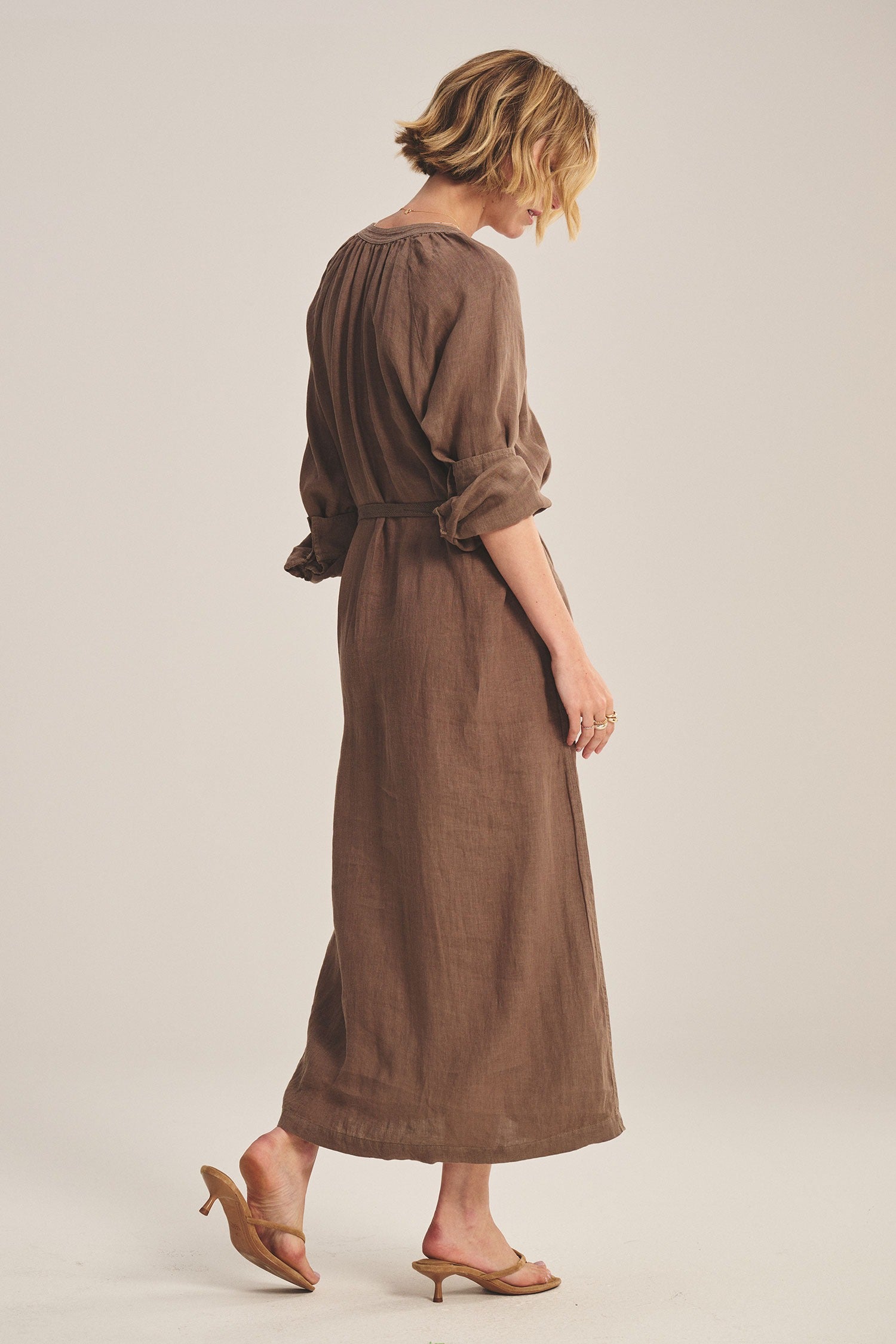 Woman wearing a brown dress on a plain background