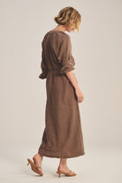 Woman wearing a brown dress on a plain background