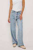 Light blue jeans worn by a person on a plain background