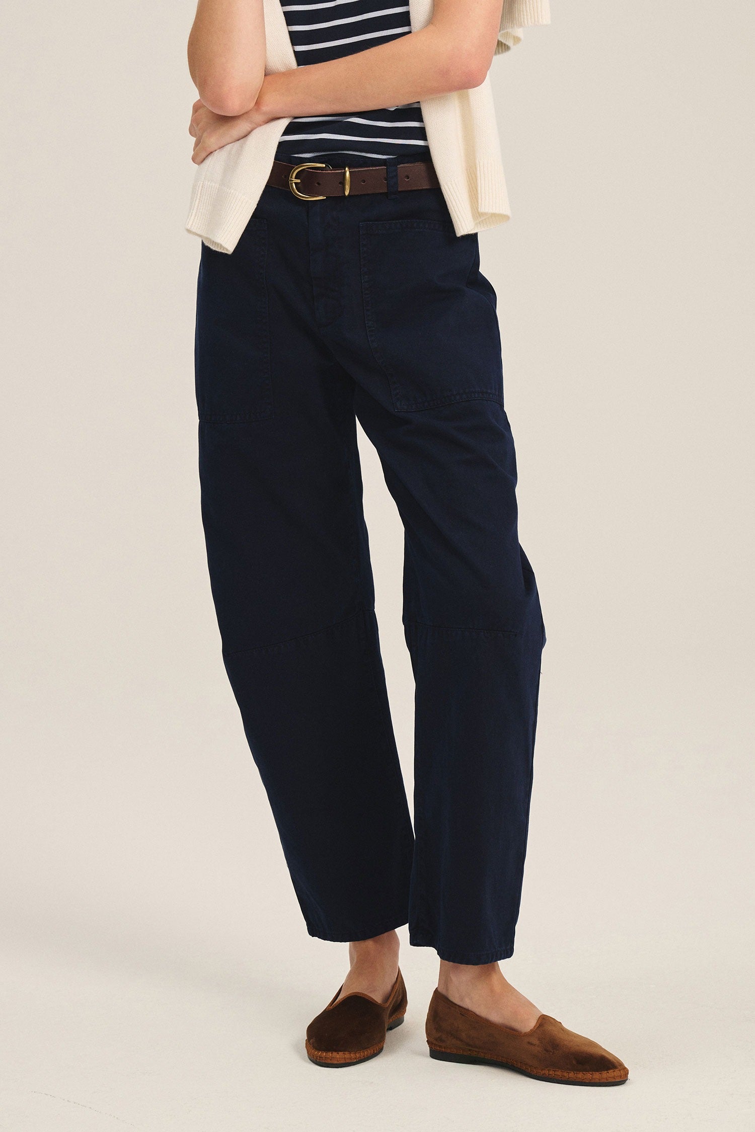 Person wearing navy pants with a white background