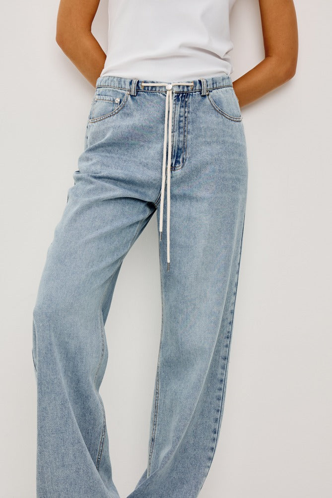 Light blue jeans worn by a person on a white background