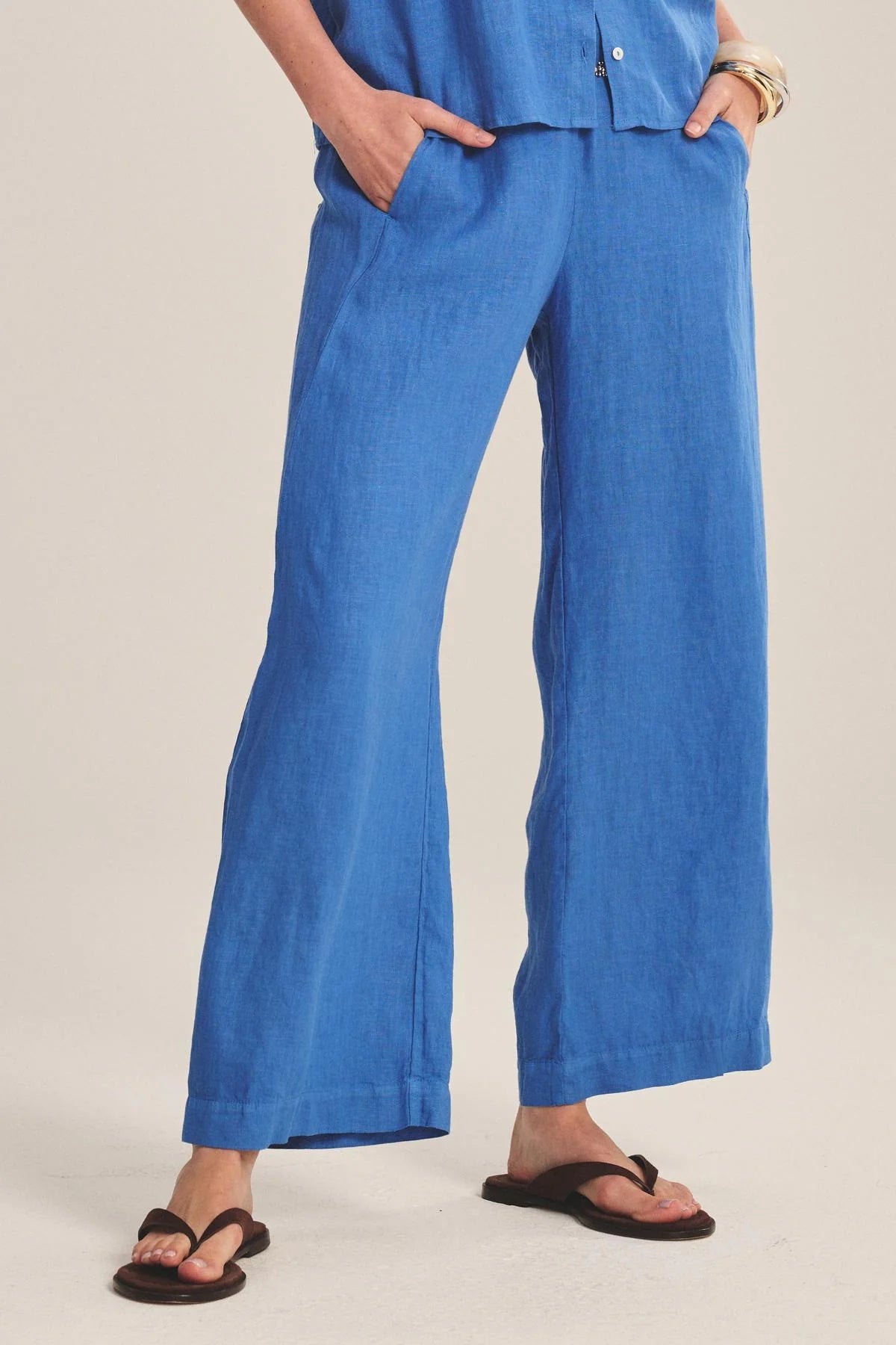 Person wearing blue wide-leg pants on a plain background