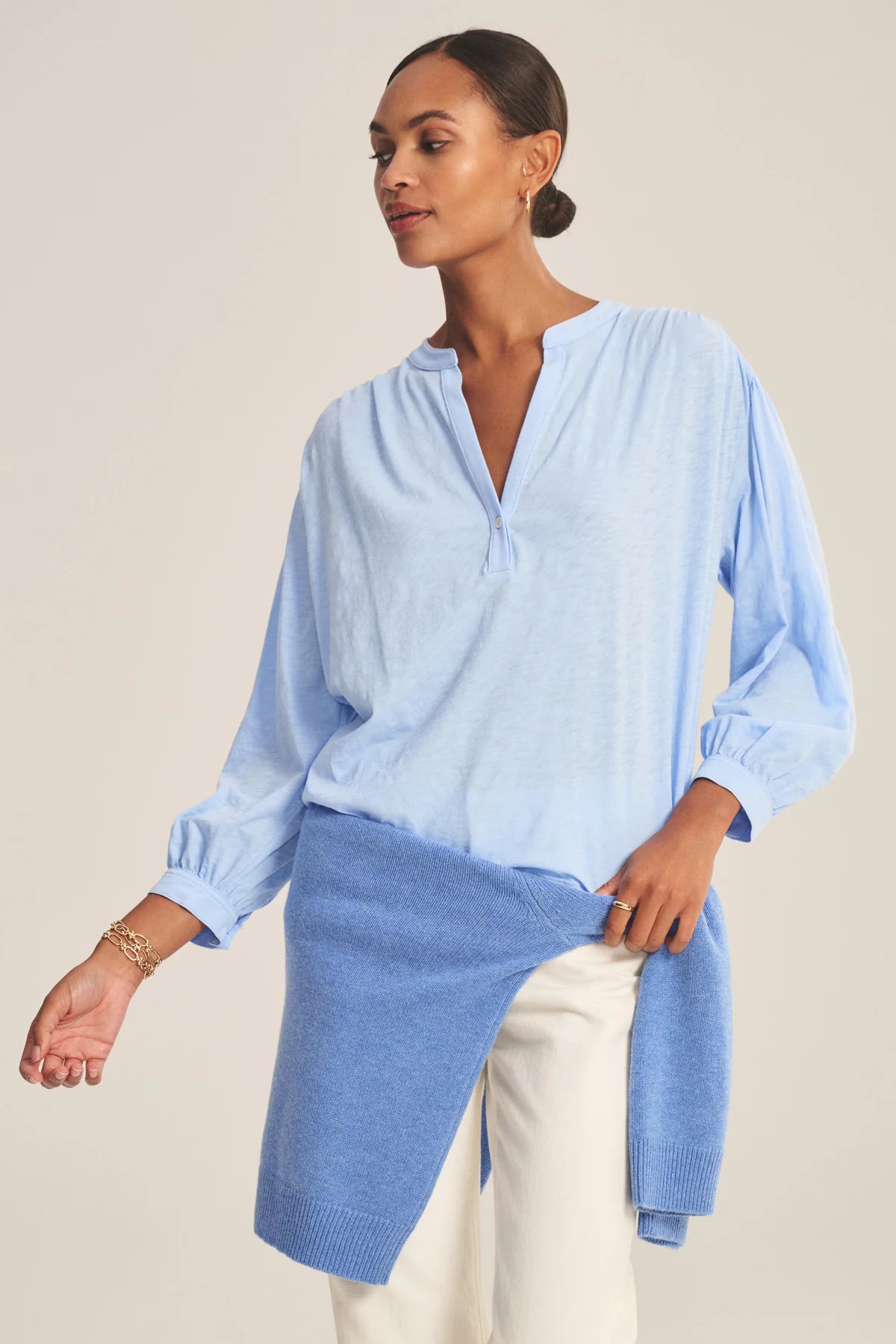 Woman wearing a light blue blouse with a neutral background