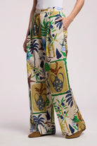 Tropical patterned pants worn by a person on a white background