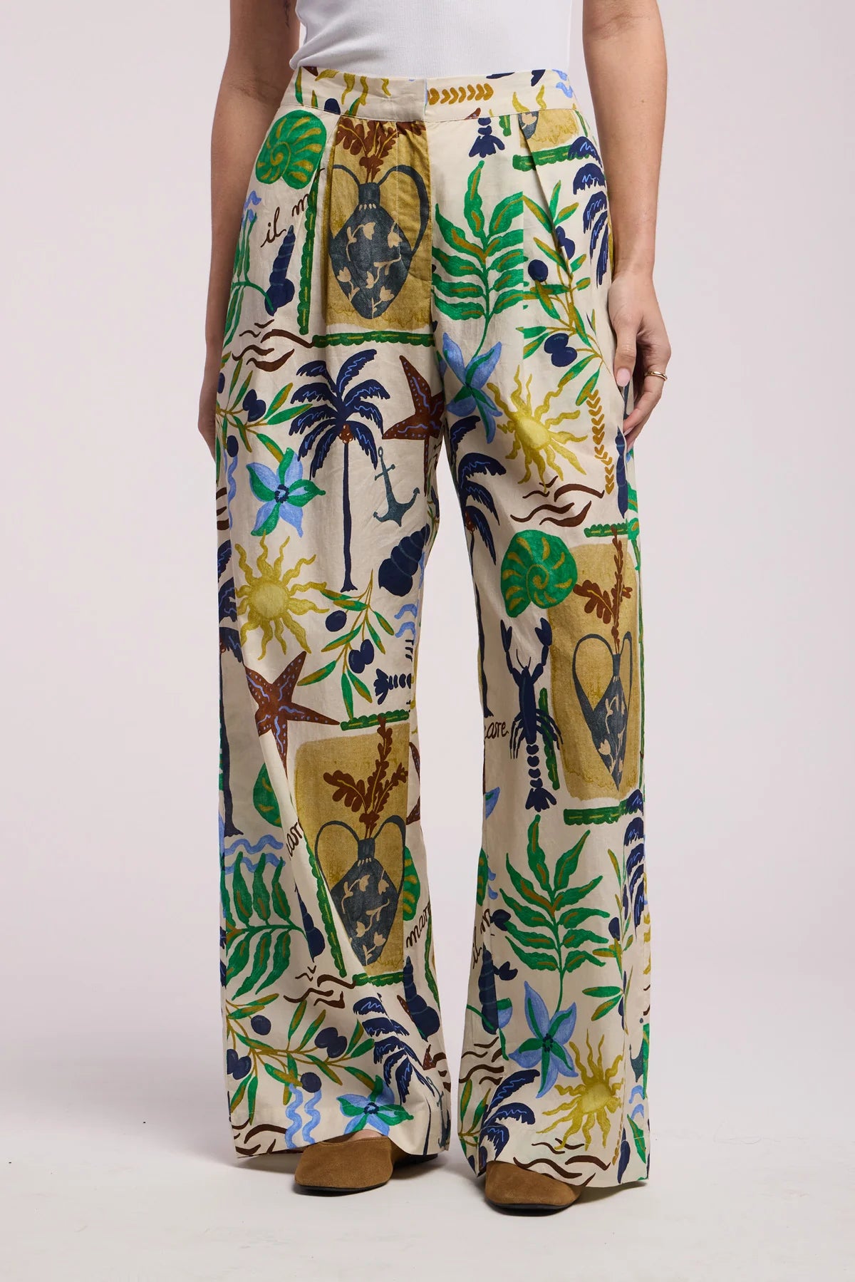 Tropical patterned pants worn by a person on a white background