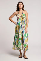 Woman wearing a colorful floral dress on a plain background