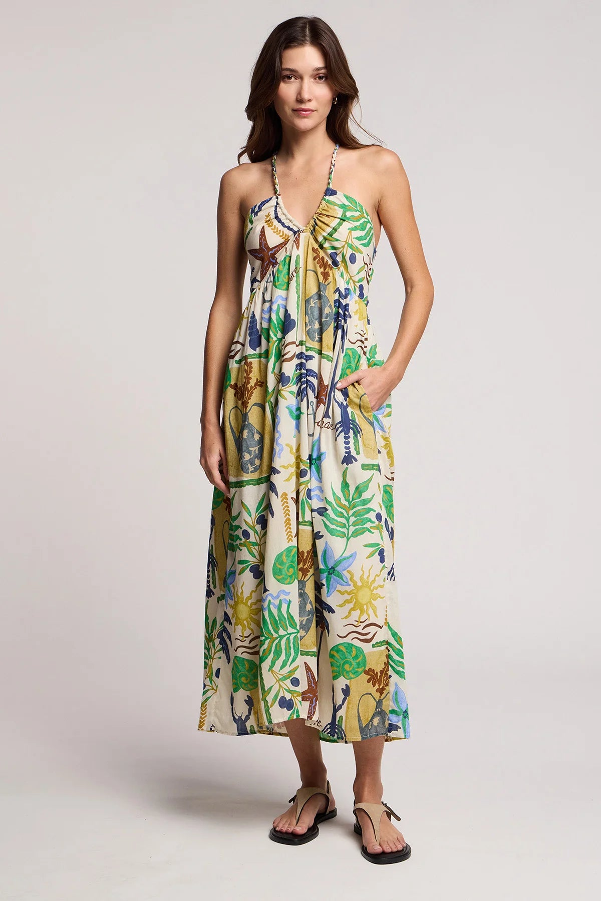 Woman wearing a colorful floral dress on a plain background