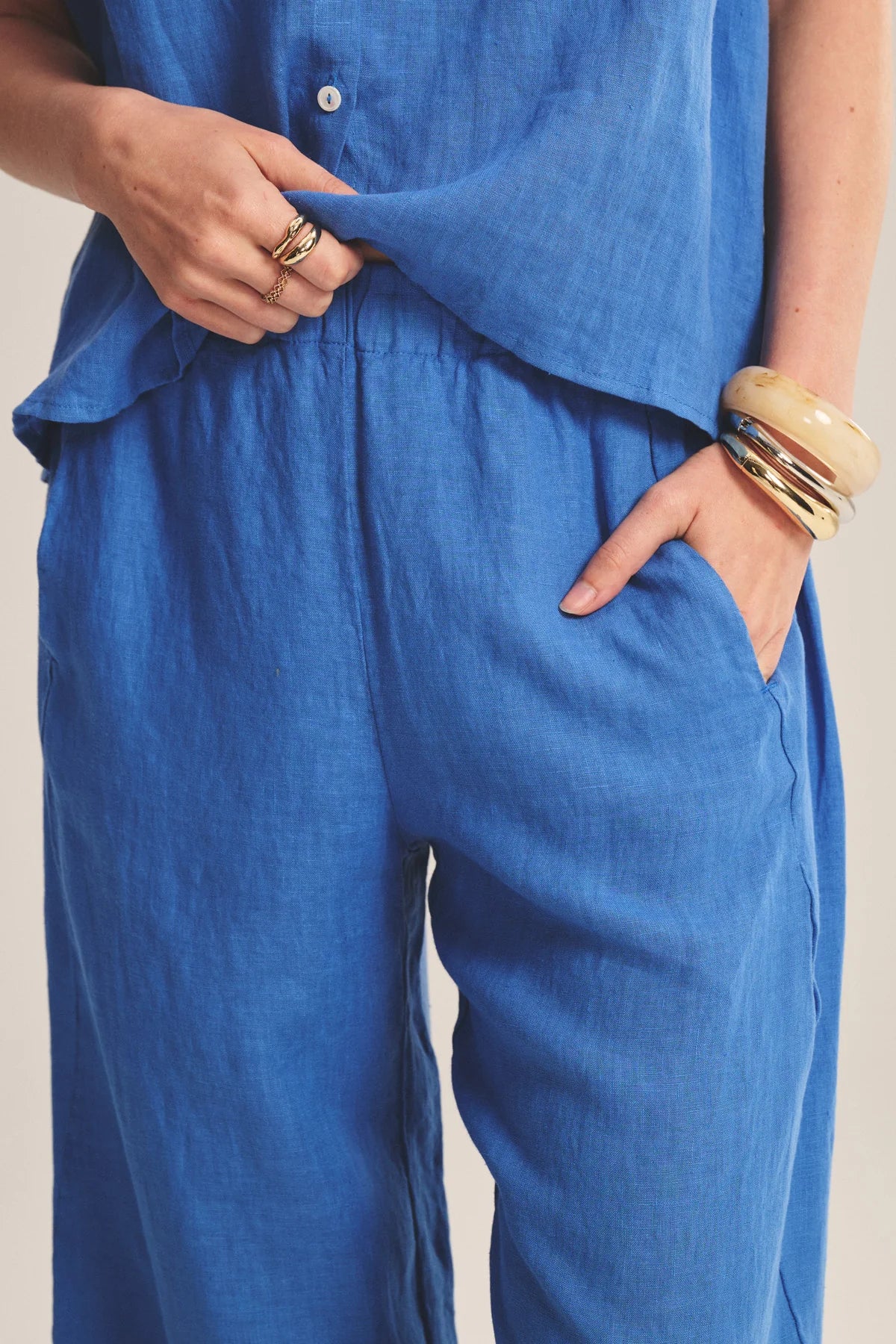 Person wearing a blue outfit with hands in pockets against a neutral background