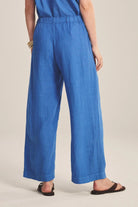 Person wearing blue pants on a beige background