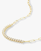 Gold necklace with clear gemstones on a white background