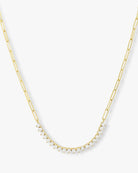 A gold paperclip chain necklace featuring a curved row of small clear stones at the center, displayed against a clean white background.
