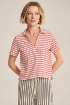 Woman wearing a red and white striped shirt against a plain background