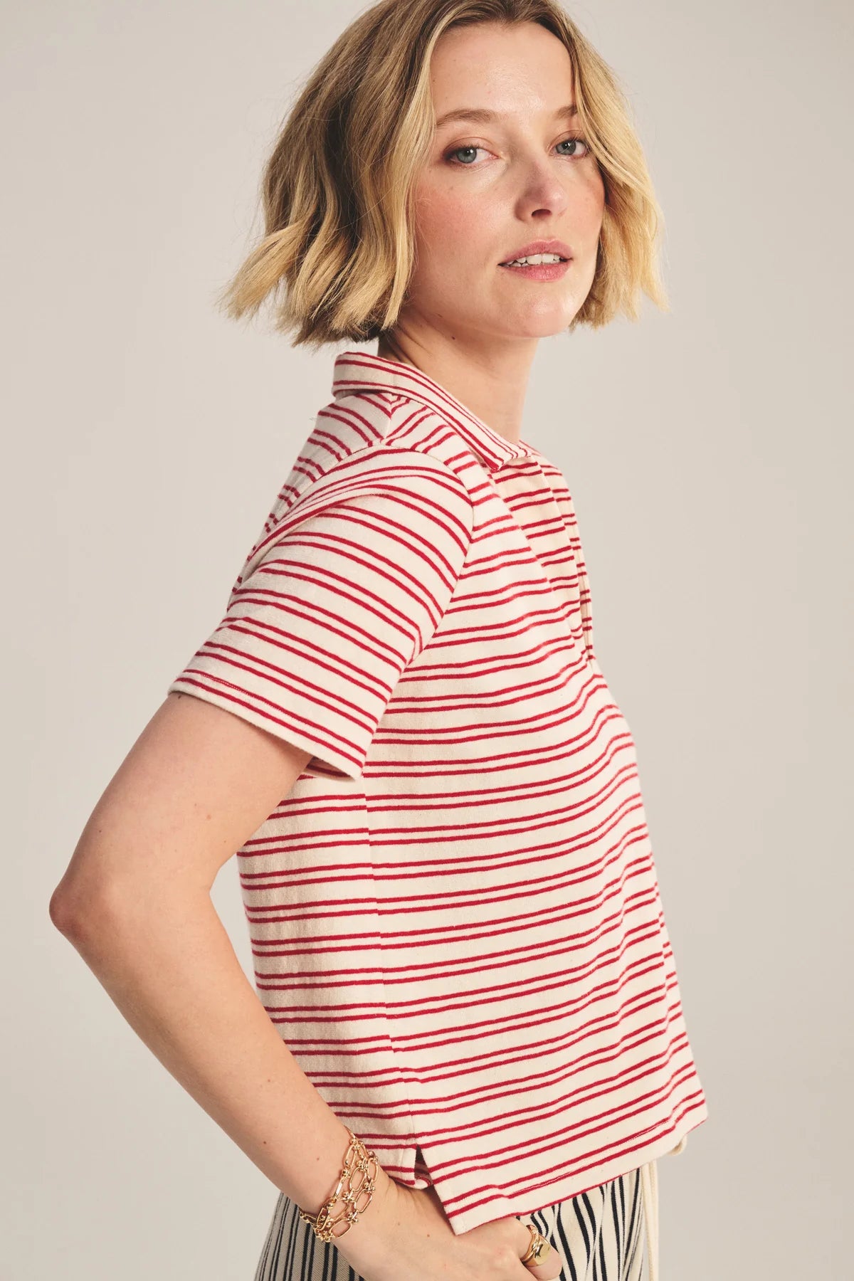 Woman wearing a red and white striped shirt against a plain background