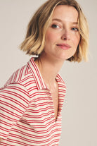 Woman wearing a red and white striped shirt against a plain background