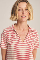 Woman wearing a red and white striped shirt against a plain background