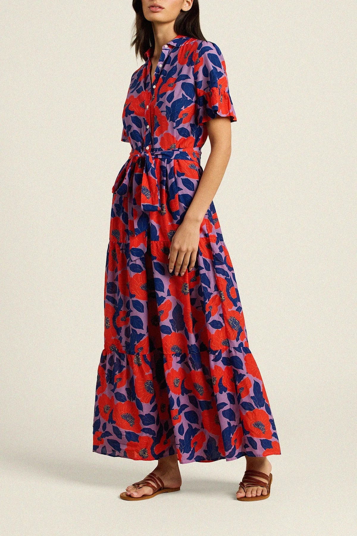Woman wearing a red and blue floral dress on a beige background