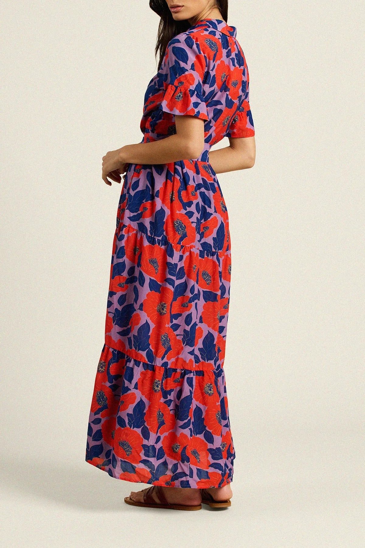 Woman wearing a colorful floral dress on a beige background