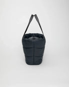 Black puffer bag with a strap on a white background