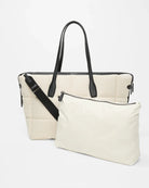 White handbag with black straps on a white background