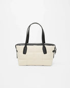 Beige handbag with black handles on a white background
