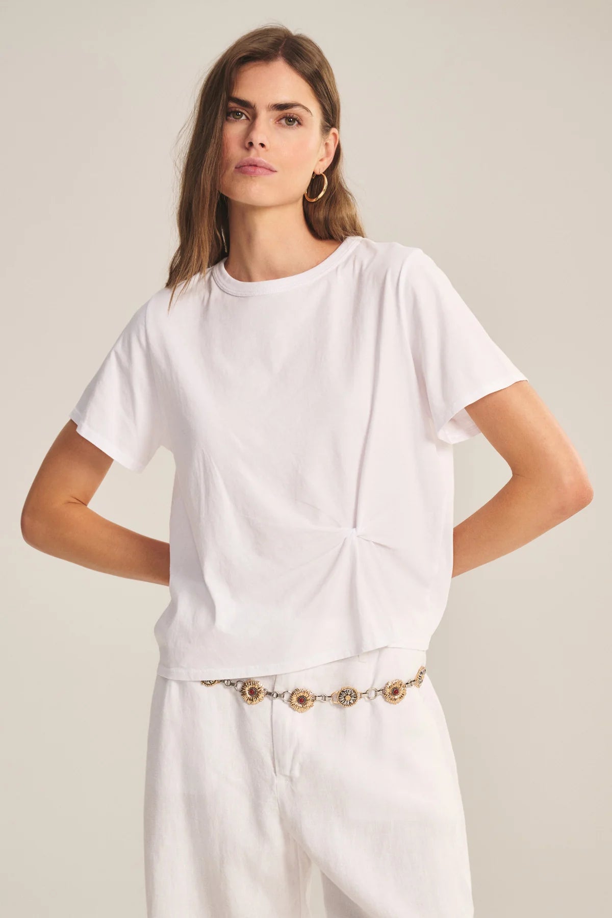 Woman wearing a white t-shirt and pants on a plain background