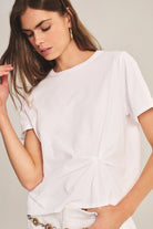 Woman wearing a white t-shirt against a plain background