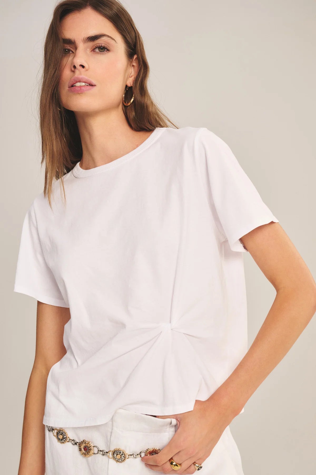 Woman wearing a white t-shirt against a plain background