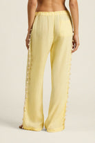Yellow pants worn by a person on a beige background