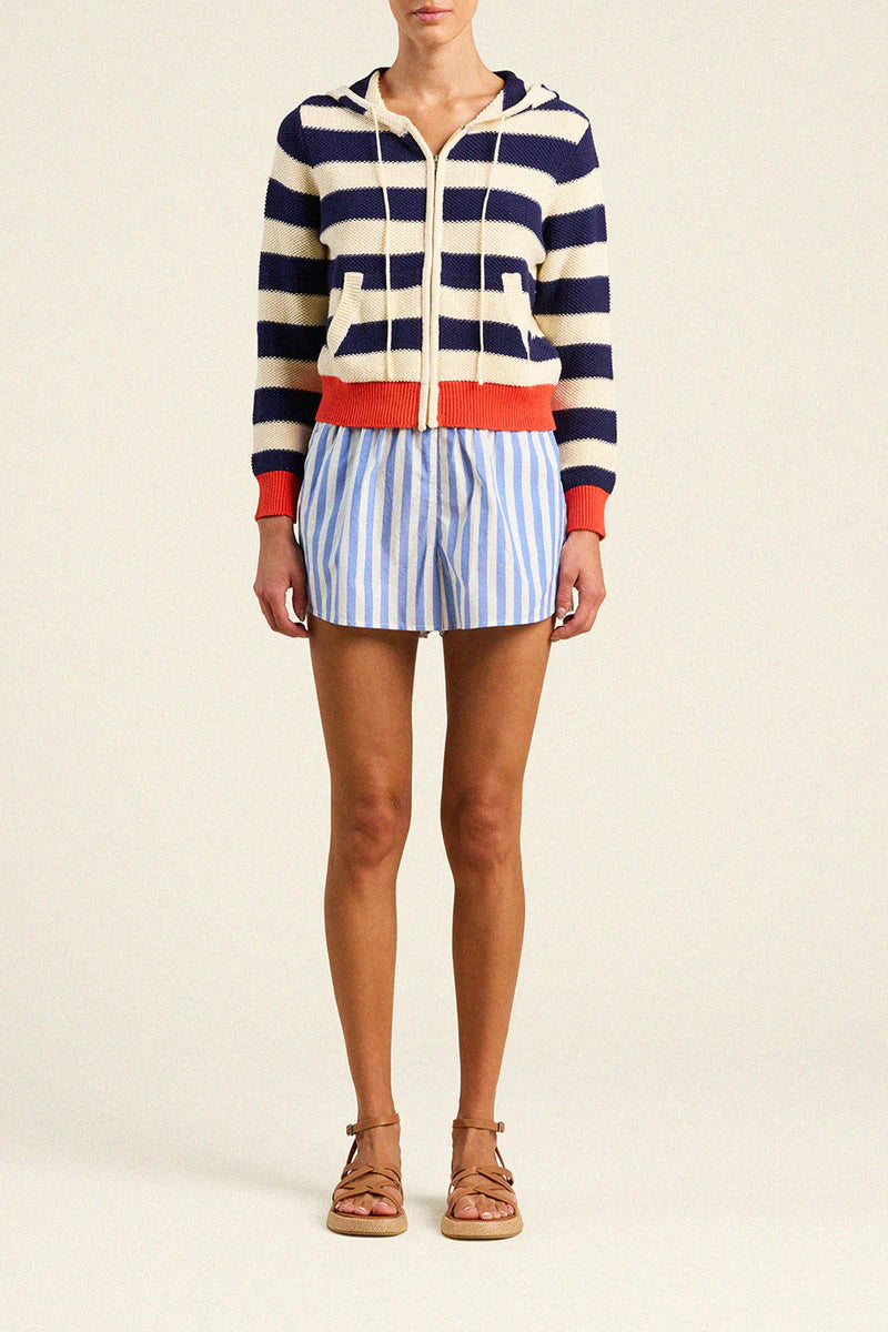 Person wearing a striped sweater and shorts on a plain background