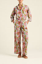 Person wearing a floral jumpsuit on a plain background