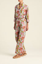 Person wearing a floral jumpsuit on a plain background