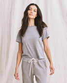 Woman wearing a gray outfit with a plain background