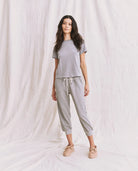 Woman wearing a gray pajama set against a white background