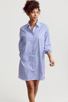 Woman wearing a blue and white striped shirt dress on a plain background