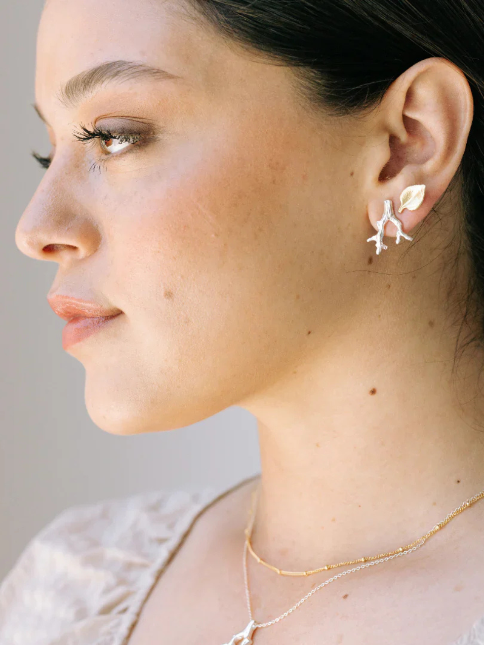 Close-up of a woman wearing earrings with a neutral background