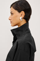 Woman wearing a black jacket with a white background