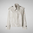White raincoat with black buttons on a light gray background