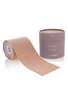 A roll of nude beige shape tape with a matching cylindrical container, both branded 'NOCO' and 'NEW YORK', on a clean white background.