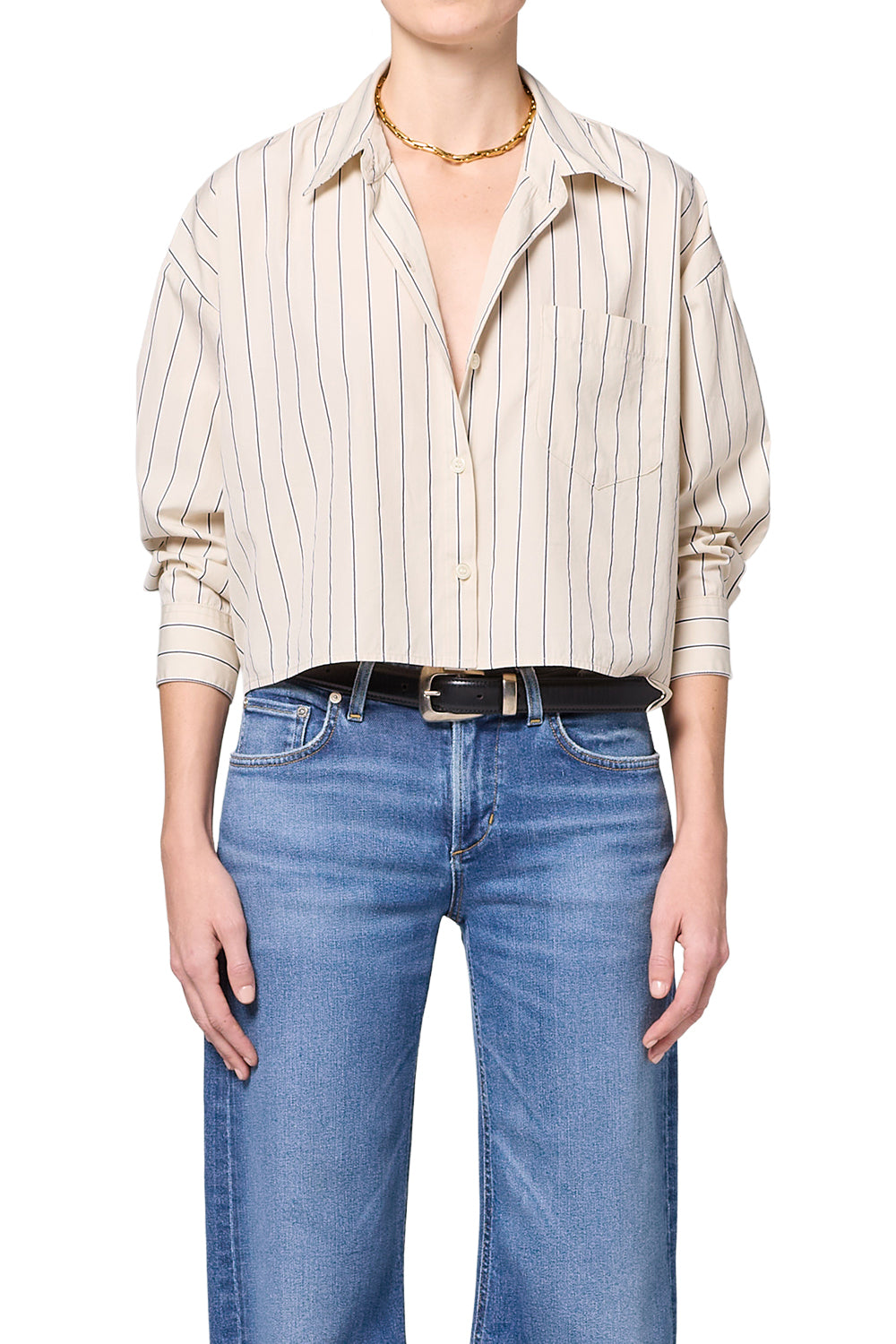 Person wearing a striped shirt and blue jeans on a white background