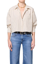 Person wearing a striped shirt and blue jeans on a white background