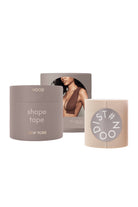 Three New York Nood shape tape products on a white background: a gray tube labeled 'shape tape NEW YORK', a beige roll with a gray circular 'ST#DOO' logo, and a gray box featuring a model photo.