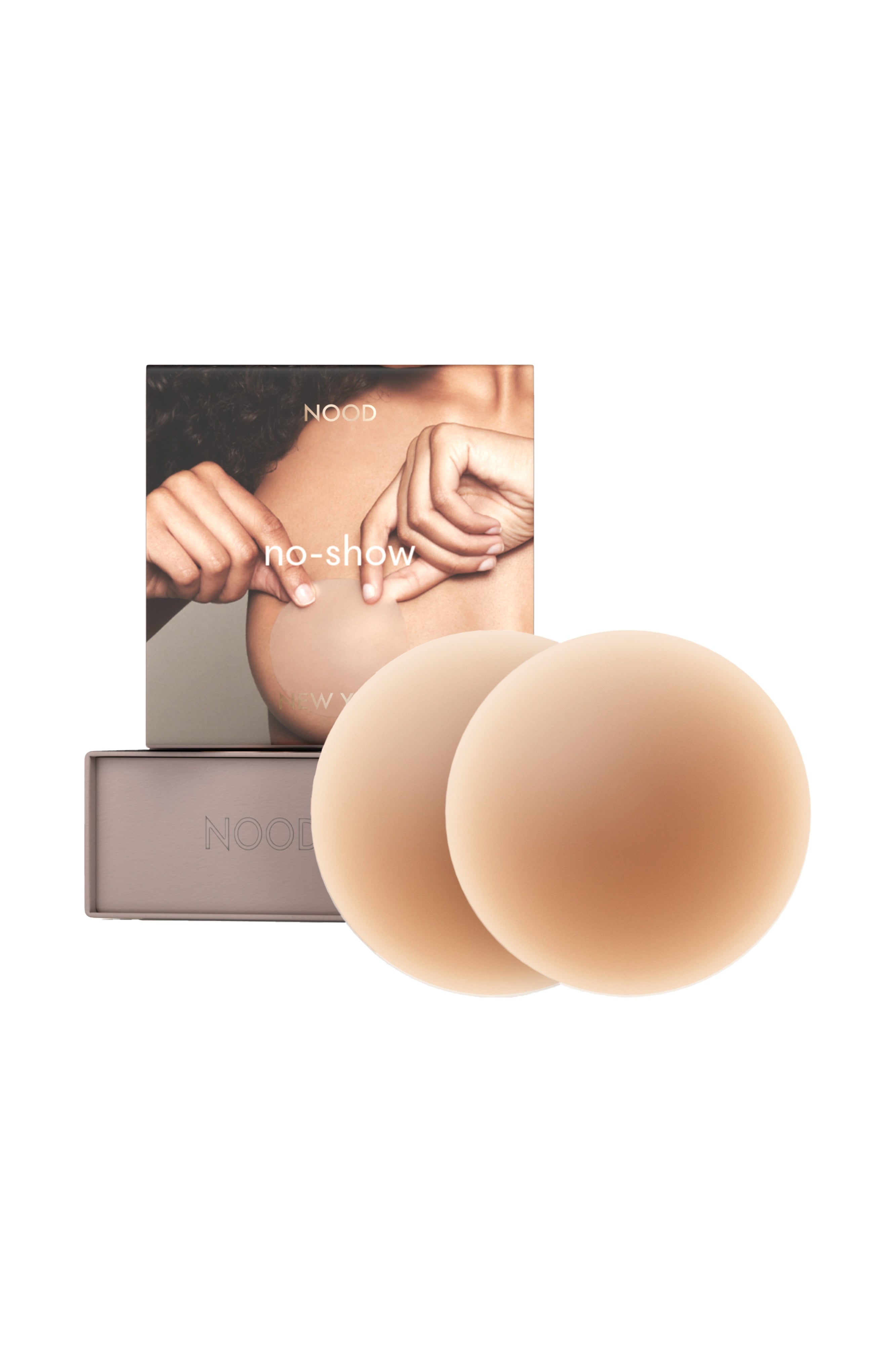 Two nude-colored silicone breast mimics displayed in front of their grey packaging box and card insert on a solid white background.