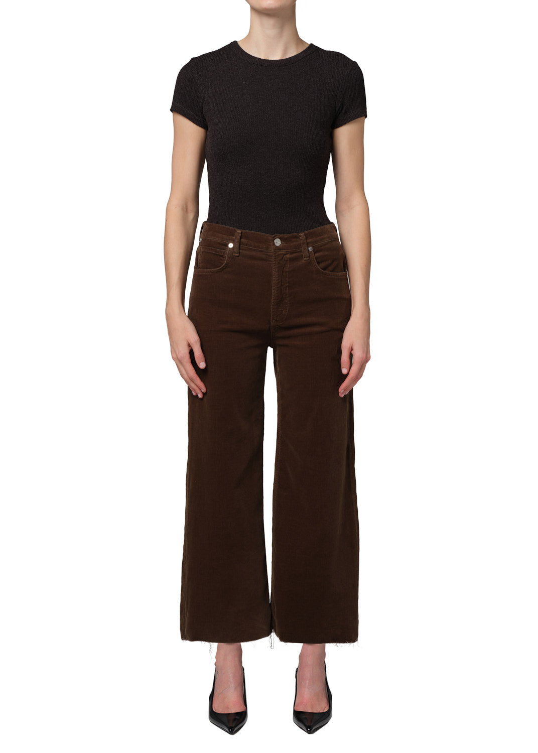 Person wearing a black top and brown wide-leg pants on a white background