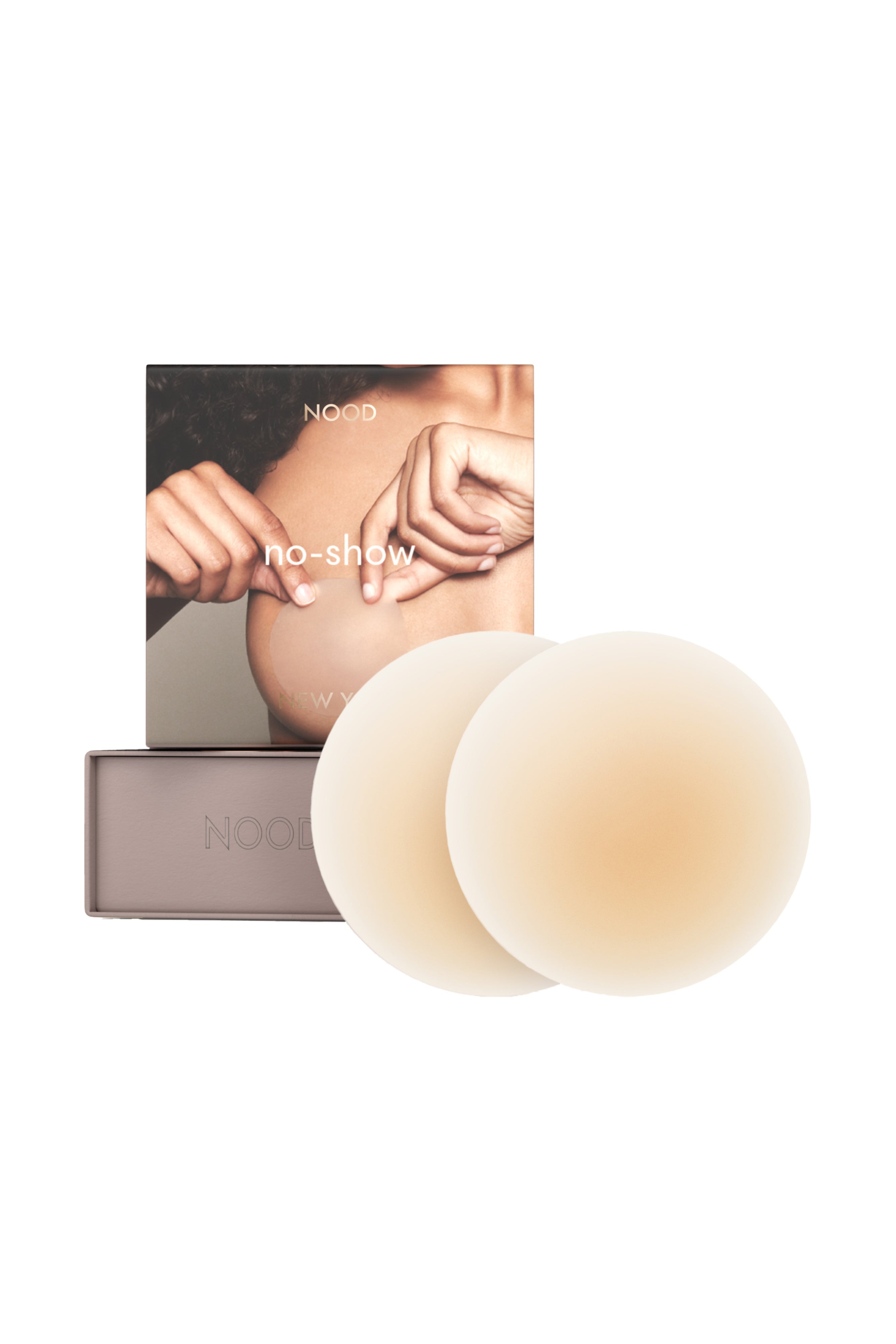Two nude-colored silicone breast mimics displayed in front of their grey packaging box and card insert on a solid white background.