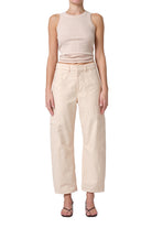 Woman wearing a beige tank top and pants on a white background