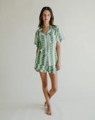 Woman wearing a green and white striped dress on a plain background