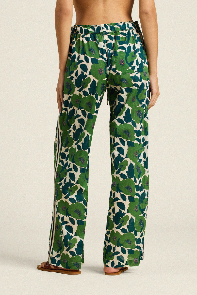 Green patterned pants worn by a person on a beige background