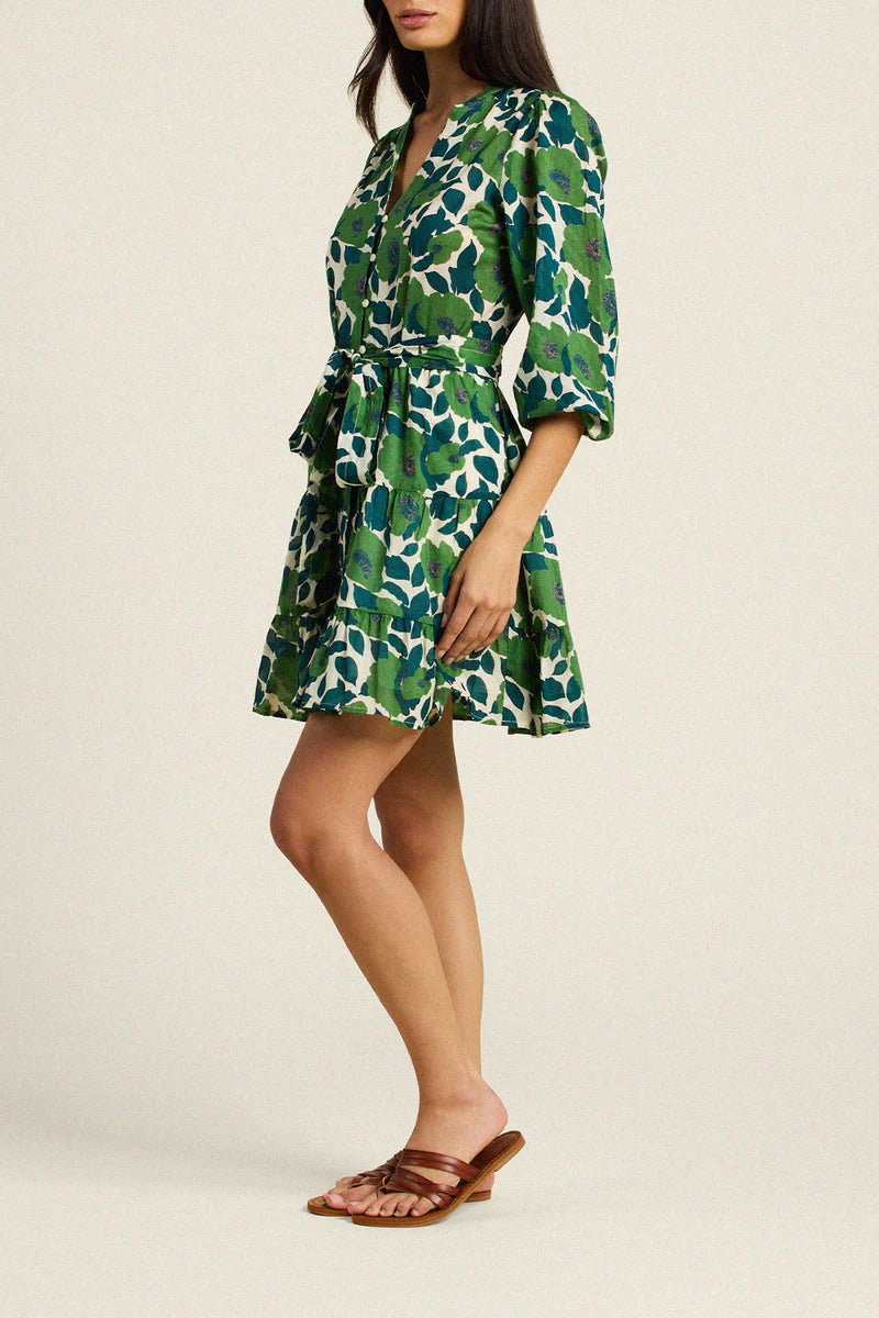 Woman wearing a green floral dress on a beige background