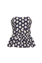 Navy strapless top with white polka dots on a white background