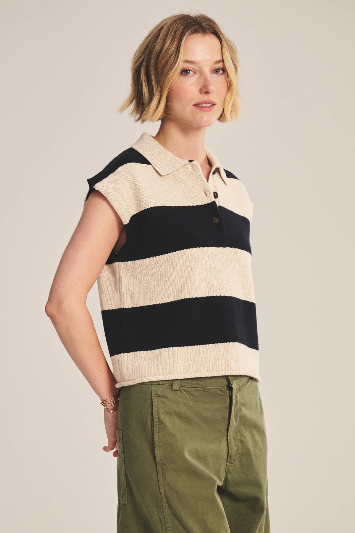 Woman wearing a sleeveless striped shirt with a neutral background